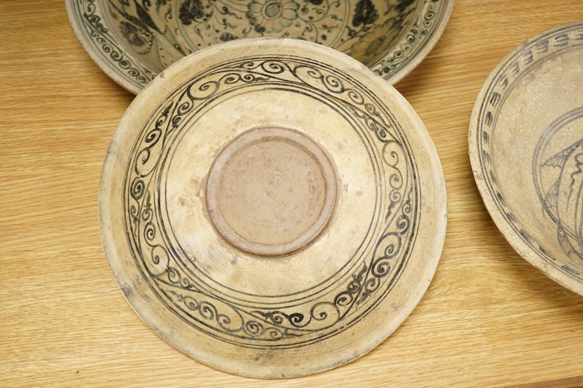 A group of three Thai underglaze blue or black crackle glaze dishes, two decorated with fish, largest 38cm in diameter